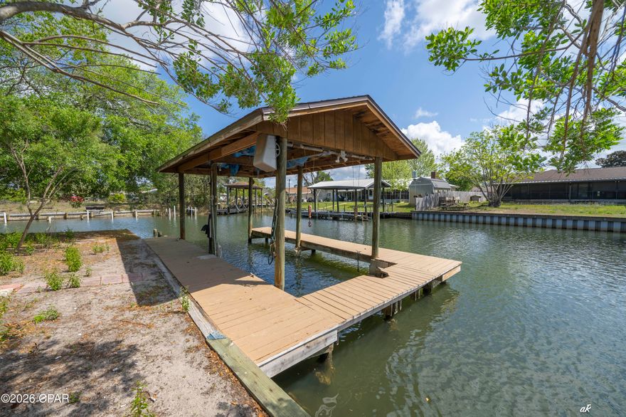 DEEP WATERFRONT LIVING WITH DIRECT GULF ACCESS (10 MINUTE BOAT RIDE TO WEST BAY, 10 MINUTES TO ST. ANDREWS BAY, 17 MINUTES TO SHELL ISLAND) - BRING A BIG BOAT - NEVER WORRY ABOUT WAITING FOR THE RIGHT TIDE.
Your best life awaits at 1311 Capri Drive, Panama City, FL. This expansive 4-bedroom, 2.5-bath home on a corner lot blends coastal convenience with thoughtful upgrades and flexible indoor/outdoor living.

Highlights:
Private dock with a 10,000 lb boat lift on the corner and quick access to open water ideal for fishing, cruising, and sunset outings. Canal depth 20'.
Versatile floor plan: living room, den, and a bright Florida room provide multiple spaces to relax or entertain.
Recently remodeled kitchen with tile backsplash, easy-clean appliances, large pantry, and exposed ceiling beams open to wide living and dining areas with hardwood flooring throughout.
Two stone fireplaces, including a striking double-sided unit between sliding glass doors that opens to the main deck.
Large first-floor laundry room and crawl space under the stairs; open-air patio at the first entry and multiple entrances off the deck for seamless indoor/outdoor flow.
Spacious back porch with a fish-cleaning station perfect for anglers and outdoor gatherings.
Second-floor layout features a second master suite with oversized his-and-hers walk-in closets and an additional closet, plus a large private deck with distant West Bay water views. Two guest bedrooms and a shared bath sit conveniently between them.
New exterior paint and well-maintained finishes throughout.
Short-term rental allowed.
Located in an established waterfront neighborhood close to beaches, marinas, shopping, and dining, this property offers true coastal living with easy access to everything the Gulf Coast has to offer. Schedule your showing to experience the lifestyle and waterway access firsthand.