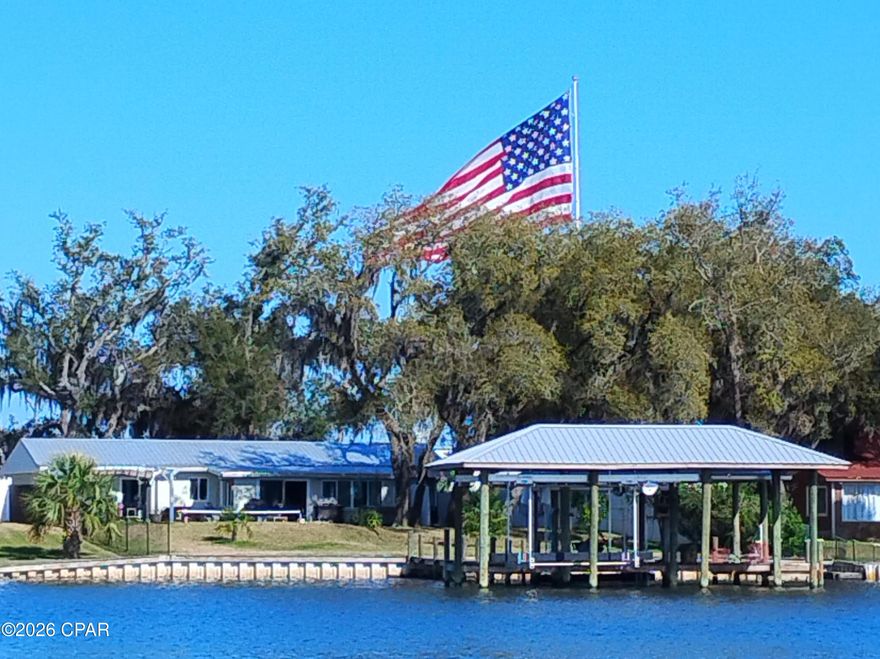 A Waterfront home that is close to everything is here in this beautifully updated 3-bedroom, 2-bath home with additional office/flex areas.  Stunning waterfront views and a home which offers the perfect blend of the boating lifestyle and turnkey coastal living. Situated on a deep 75' x 188' waterfront lot, the property features a professionally installed seawall, twin covered private docks with dual boat lifts capable of accommodating up to a 32' boat and a 25' boat (or 2 jet skis) -- a rare setup for serious boaters seeking protected water access with quick access to the North Bay and Gulf of America.
Inside, the home has been fully updated and designed for comfortable waterfront living. Hurricane-impact windows provide peace of mind and energy efficiency, while the open and inviting interior creates a bright coastal feel throughout. New metal roof 2021, electric and water infrastructure has all been replaced, permitted and updated. 
A standout feature is the impressive 24' x 36' detached two-car garage complete with a conditioned area -- perfect for a workshop or hobby area. 
Step outside to your private backyard retreat featuring a stunning 15' x 38' resort-style pool with massive live oaks. Enjoy the shaded pergola area with expansive waterfront views, and plenty of room to entertain, relax, or enjoy sunset evenings on the water. 
The fully fenced property includes a private electronic gate, creating a secure and secluded waterfront retreat with ample space for vehicles, boats, and outdoor entertainment.  No HOA and is in Bay County zoning. 
Whether you're searching for a primary residence, easy-care second home, income-producing property or premier boating property, this move-in-ready waterfront gem delivers exceptional value with upgrades already complete -- including seawall, covered docks, boat lifts, salt-water pool, interior renovations, newer garage, gated and fenced yard.  Co-owner is a licensed real estate agent. 
Waterfront living at its best.