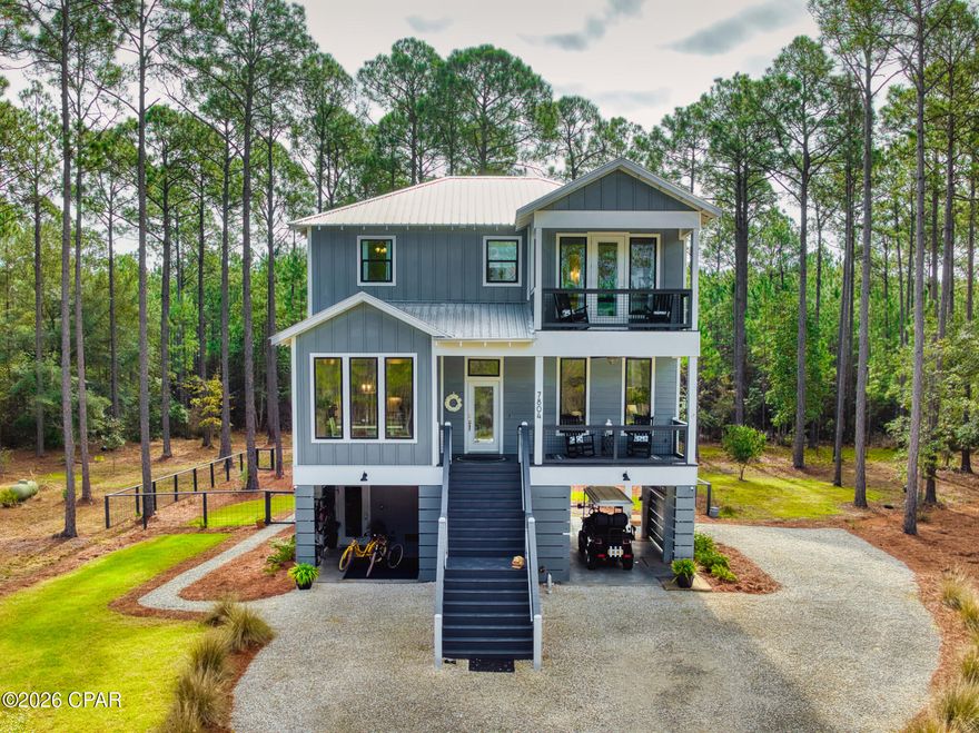 Welcome to 7804 S Chipper Trail, located on the west end of Rivercamps on Crooked Creek: Panama City Beach's hidden wooden oasis. This home offers the rare feeling of living in a luxury treehouse, with four spacious porches that capture serene views of the surrounding natural landscape. Designed with both privacy and functionality in mind, the home provides generous storage and flexible living throughout. Inside, the main living area is crafted for every occasion, featuring a fully equipped kitchen, separate dining area with expansive windows, and living room featuring a built-in fireplace. The elevator allows accessibility for all three levels, making everyday living comfortable for all stages of life. Upstairs, the laundry room is conveniently located near the additional three bedrooms. The primary bedroom has its own private balcony, overlooking the cul-de-sac and wandering neighborhood deer. Below the main living area is a three car garage with three separate storage closets ideal for beach gear, boating equipment, and all your Florida essentials. The dedicated game room and outdoor firepit create inviting spaces for gatherings, while the fenced-in backyard provides added privacy and versatility. Rivercamps spans approximately 1,500 acres, two thirds of that being devoted to conservation. The community has a new zero-entry pool, approximately seven miles of interconnecting trails and boardwalks, boat launch and trailer storage, playground, pickle ball courts, designated campground, new west-end mailboxes, and the community has officially broken ground for the future fitness center as of November 2025! Rivercamps is nestled on the north side of West Bay conveniently located: 10 miles from the beach; less than 15 minutes to NW Florida Beaches International Airport (ECP); FSU/TMH Medical Campus; Watersound West Bay Center along 79 (Publix projected to open in 2026). By water, enjoy a 45 minute boat ride to Shell Island, with the future Point South Marina West Bay also on the horizon.