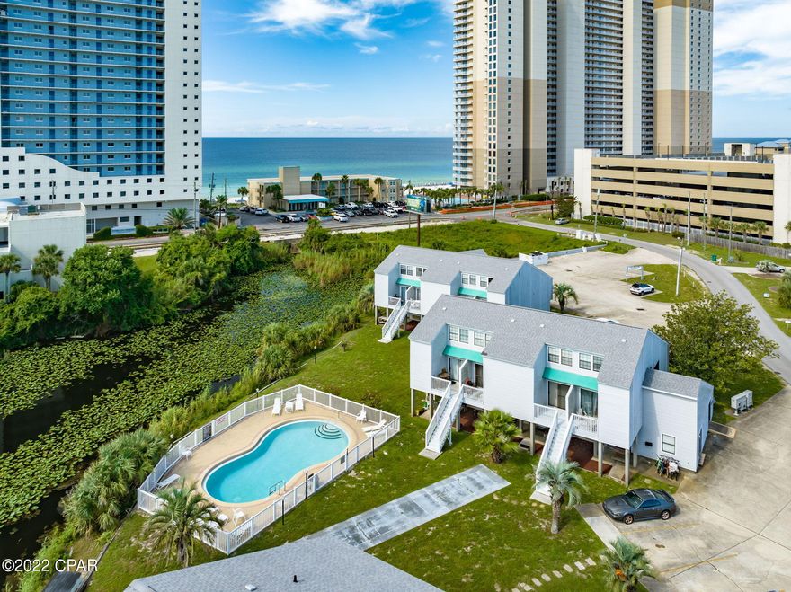 This ground-level, lakefront condo is located right across the street from the Gulf of Mexico and less than 1 mile from Pier Park! This studio beach condo is perfect for a second home, vacation rental, or for affordable long term efficiency living. It is tastefully furnished & decorated, features tile floors and updated kitchen.  You really can have it all here and not break the bank. Sit on your private back patio and watch stunning sunsets over the lake, or enjoy a dip in the community pool located directly behind the unit. Lullwater Lake Beach Condominiums is a low density complex with NO elevators. Owners have ample parking, a lakefront community pool, bbq grills, and the world's most beautiful beaches are only a short walk away. Room dimensions, age, Sq footage, HOA fee are approximate, please verify if important.