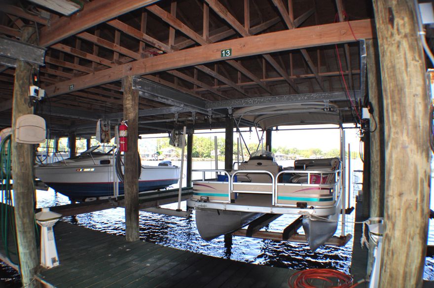 CURRENTLY UNDER CONTRACT, SELLER ACCEPTING BACKUP OFFERS.  Waterfront condo with a COVERED BOAT SLIP AND LIFT THAT ACCOMMODATES PATIO OR V HULL BOAT on Grand Lagoon! Double motor lift to handle larger boats! 25 foot boats are stored here!  This Greenwood Estates unit has 3BR/2.5BA & a great view of the water from almost every room! The back part of the condo was closed in for an extended living area & additional features include tile floors, updated kitchen appliances, walk-in closets and extra storage, & a new AC unit.  Greenwood Estates amenities include a community pool, covered picnic/grilling area, and a private boat dock.  Boat slip #13 conveys with this unit & it is fitted for both a patio boat or a larger boat.  All info is approx. and must be verified by Buyers if important.