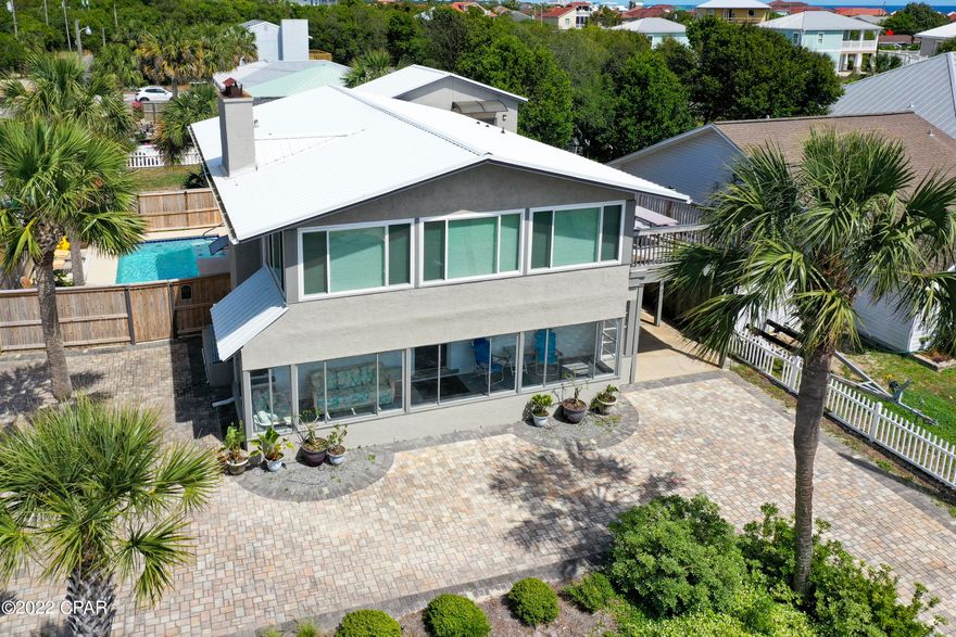 This beautiful beach oasis has all the features you could want. 2 bedrooms are located downstairs and the other 2 are upstairs. Each floor has its own kitchen and a fireplace in the living area. The first floor features a beautiful Florida room while the second has a large deck to look out toward the beach. There is a separate theater room as well. Outside, is a dream come true. There is a swimming pool with a waterfall, a hot tub, a sauna and an outdoor kitchen. This outdoor kitchen features a full size refrigerator, ice maker, grill, gas burners, and a frozen drink maker. The home comes fully furnished and short term rentals are allowed. There is a locking door at the top of the interior staircase so that the units could be rented separately if desired. The top floor sleeps 5 while the bottom sleeps 4. This would make a fantastic family home or investment property. This is a one of a kind property that should not be missed.