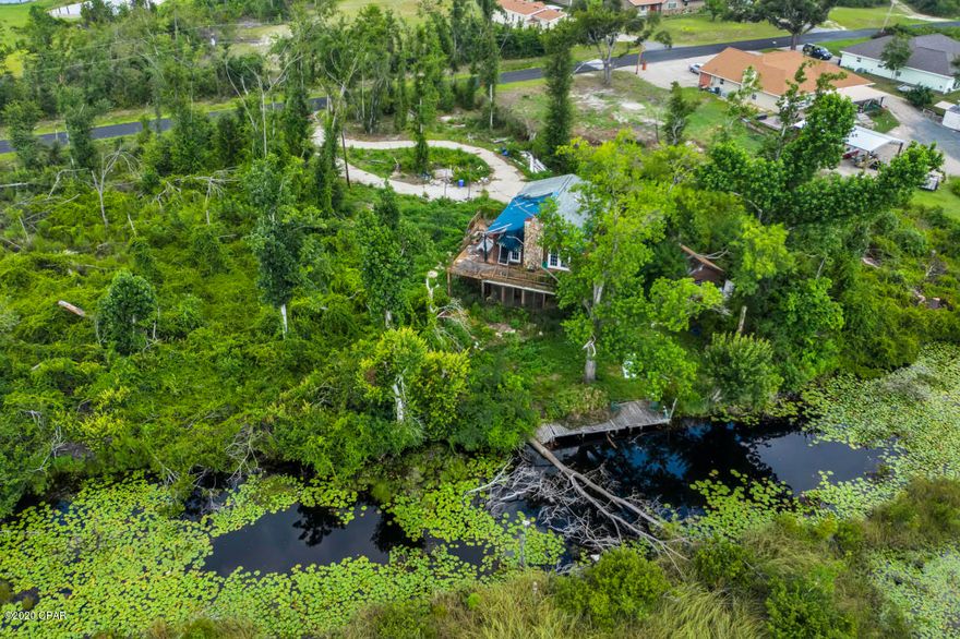 Excellent Location, 19 miles to the beaches, that are acclaimed as the worlds most beautiful ! The current home may be taking down to build your dream estate, or the right buyer could possibly put it back together. This almost 1/2 acre, waterfront lot has a well, septic, electricity and circular driveway. Everything was working prior to Hurricane Michael, buyer should verify. This location is a secluded, private environment in a great neighborhood, with great views from the dock and the house, offering Vistas, seclusion and privacy. Plenty of room for your boats and recreational vehicles. Pictures taken 7/20/2021