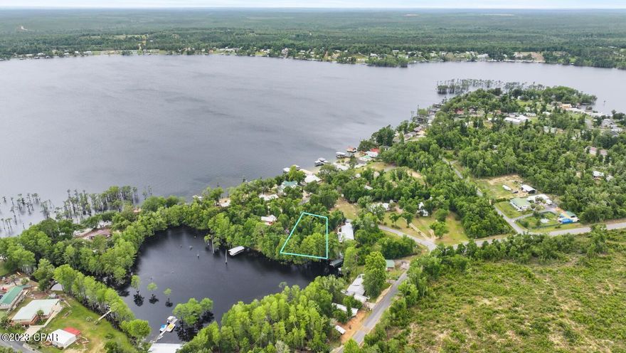 Nestled along the serene eastern cove of Compass Lake, this expansive double lot (.53/acres+/-) spans over half an acre of pristine waterfront terrain within the scenic surroundings of a 581-acre spring-fed lake. Boasting approximately 146 feet of waterfront, this parcel presents an ideal canvas for crafting your dream waterfront residence.

Beyond its picturesque waterfront, this property offers convenient access via a paved road and is adorned with majestic oak and Cypress trees, adding to its natural allure. Situated in the quaint community of Holiday Estates, characterized by deed restrictions ensuring a harmonious environment, this lot promises tranquility and exclusivity.

Conveniently located just a short drive from Highway 231, this idyllic locale offers swift access to the interstate, making journeys to nearby destinations such as Dothan and Panama City Beach effortless, each less than an hour away. Embrace the opportunity to create your waterfront oasis amidst the beauty and convenience of this remarkable location.