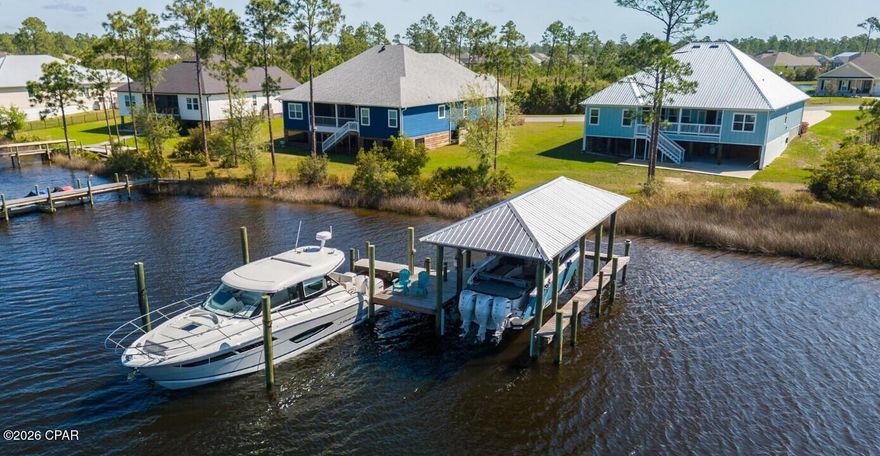 Waterfront Paradise with Boat House, Gulf Access, and Breathtaking Sunset Views Discover the ultimate waterfront lifestyle in this stunning 5 bedroom, 3-bathroom home featuring ~100 feet of prime waterfrontage and everything you need for seamless coastal living. With a 12,000 lb boat lift, a wet slip accommodating up to a 4 ft draft, and a 36 ft boat house. This property is perfect for boaters and water enthusiasts. The flow-through decking on the swim platform enhances durability and comfort, while the 50-amp service plug-in ensures your vessel is always ready for your next adventure. Step inside to an inviting open-concept floor plan designed for both relaxation and entertaining. The spacious living area is bathed in natural light, offering stunning water views from nearly every angle. The formal dining room is perfect for hosting special gatherings, while the flex space can serve as a home office, playroom, or additional lounge area. Outside, the oversized driveway provides ample parking for family and guests Downstairs, you'll find an expansive entertaining space designed for making memories, complete with a firepit—the perfect spot to unwind and enjoy the breathtaking sunset views over the water. This exceptional waterfront home seamlessly blends comfort, functionality, and luxury. Whether you're an avid boater, a sunset lover, or someone seeking a peaceful retreat, this property offers it all. If important, buyer to verify all information and measurements.