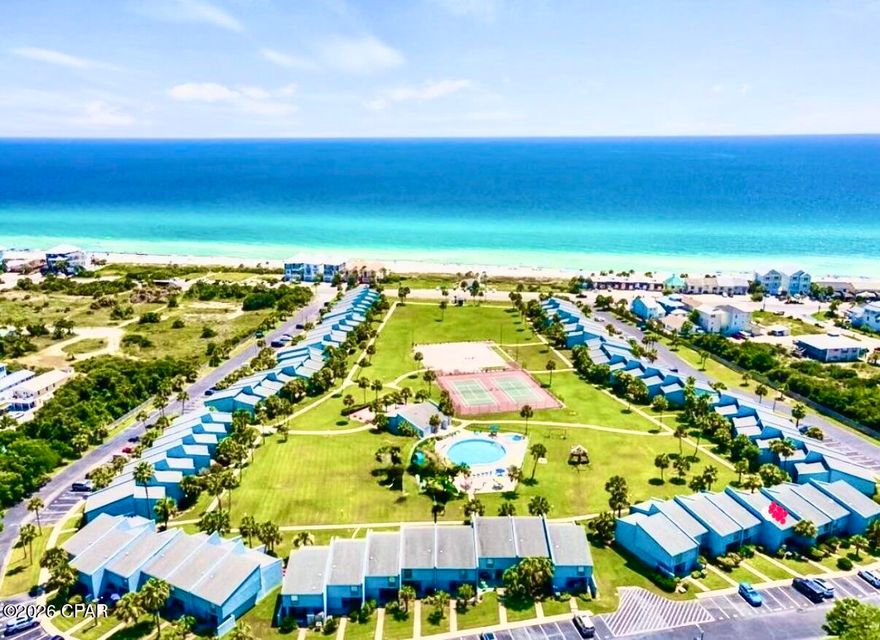 SLEEPS 10! These Condos on the coveted west end rarely come on the market, especially with a private deeded beach! This updated unit is 4th from right on bottom of ''U'' with wide panoramic view of the green! Located 350' from the Gulf w/ private deeded beach & private gazebo with viewing area to relax and enjoy the view!

The Sellers thought this was going to be their forever home so it was never used as a rental! This fully renovated unit has new lighting throughout.  Kitchen has custom tile backsplash w/ 15'' deep solid wood white cabinets w/ soft-close/deep drawers w/ dove-tailing combined w/ a beautiful quartz countertop. Custom solid wood beadboard added on adjacent wall to blend w/ existing. Deep stainless steel sink w/ dimmable light above, newer dishwasher, custom pots & pans drawers, too! Whole home was custom painted in 2024 w/ upgraded scrubbable paint & 6'' baseboards! Stairwell updated in 2024. All doors and windows are solid wood trimmed. Condo faces South to get full light all day. Back wall has 90% UV protection screens even tho the sun does not beam in. Nice sized LR with sofabed and enough room to add an extra chair. The 16' high ceiling adds so much room to this already nice sized condo! Don't miss the tongue and groove solid wood ceiling! Spectacular feeling when entering! DR seats 6 with a bench that can be added for extra guests! 1/2 bath downstairs with new cabinet and lighting. Laundry room behind it with full sized W/D. Laundry room exterior door is 36'' wide as is front door. Storm door added to enjoy fresh air.  Large walk-in owners closet. Nest thermostat. Loft area has a queen Murphy bed with beams above to blend with LR area. Some electrical outlets moved for convenience. Large Primary BR with wood beams and bottom up/top down custom shades as well as ensuite bath with updated tile shower. Guest BR has white solid oak single bunk beds with queen bed. Some units have this room with glass windows looking down into the LR - this one is private! Both bedrooms have custom extra storage above closets as well as 10' ceilings! New carpet in bedrooms w/ upgraded padding. Both baths are renovated w/ new lighting, tile flooring, vanity cabinets w/ soft close drawers.  Guest bath has bathtub/shower combo. Patio in front for relaxing as well as large patio out back to enjoy the incredible view! There is 24-hour service available daily whether it be maintenance or office manager on site. Security guard on site throughout the week. The HOA maintains the outside painting & roof, with internet, trash and water included. Sunnyside Beach & Tennis Resort is a tranquil escape located on the quiet side of PCB. Situated amidst lush greenery, this tropical paradise encompasses 18 acres within 350 ft. of the emerald waters and sugar white sand beaches. The unique quality of this resort is the private pedestrian beach access. The underpass is a well-lit tunnel under Front Beach Road which leads to the large gazebo and boardwalk that sits on the white sandy beach! The complex amenities include: tennis courts, shuffle board courts, 2 pools (one for the little ones), a playground, and a clubhouse which features: free Wi-Fi connectivity, ping-pong table, and pool table and its very own private view of the Gulf. Come see this gem of a condo!  Make it your home! No RV parking, only boat trailers and enclosed trailers, maximum 30' located in private lot beside condo. (Some personal knick knacks do not convey)