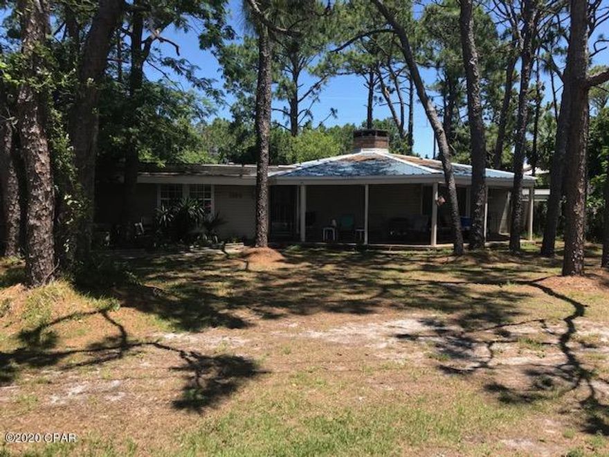 LOCATION! LOCATION! LOCATION! Beautiful half acre plus lot in the heart of east Panama City Beach.  Approx. 1/2 mile to beach! Also close to shopping, dining, and recreational activities. This fixer-upper has great potential! Large living room with brick fireplace. Tile and vinyl plank flooring throughout. 30 x 50 garage/outbuilding has lots of room for your favorite tools! Private fenced in back yard.  All measurements are approximate.  Please verify if important.