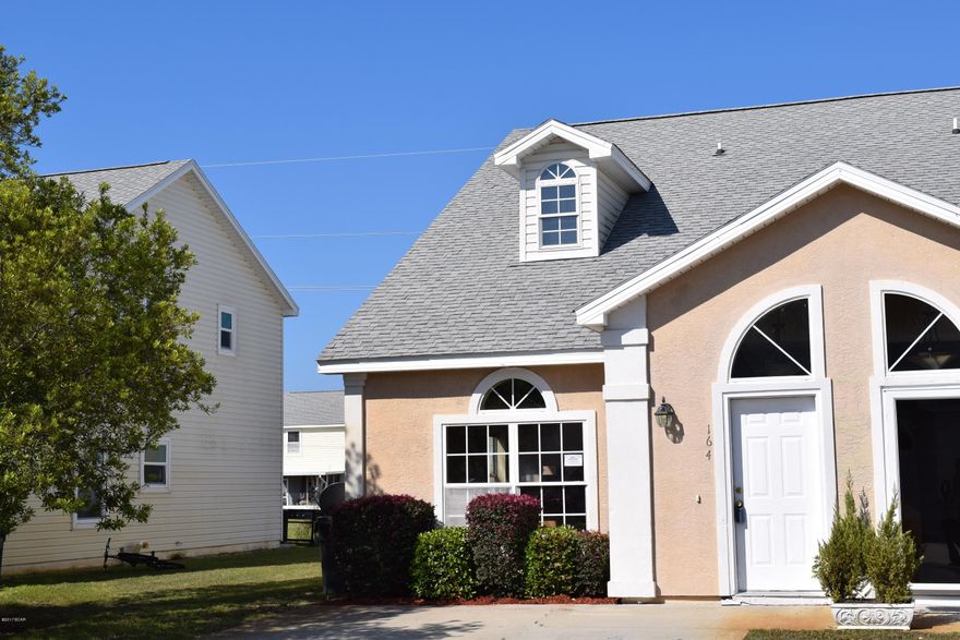 If you want turnkey, upgaded, and ready to go here is your home! Great centralized location in the heart of Panama City Beach. You will never be bored in the active Palm Cove community! Down the street from the beach and close to Pier Park, this subdivision features gated entry, two community pools, and even a volleyball court! This spacious townhouse is over 1400 square feet under air with three nice sized bedrooms. As you enter the foyer you will see a spacious living room with high ceilings, beautiful laminate flooring in the living room and an open kitchen. The whole place has the feel of beachy, open and airy, with lots of light! The kitchen is above average in size with plenty of cabinet space. A brand new stainless steel stove and dishwasher were just installed! The laundry room is located on the first floor.Also on the first floor is a bedroom with bathroom en suite. There are two additional bedrooms and a bathroom  on the second floor.  And all the walls were just painted!