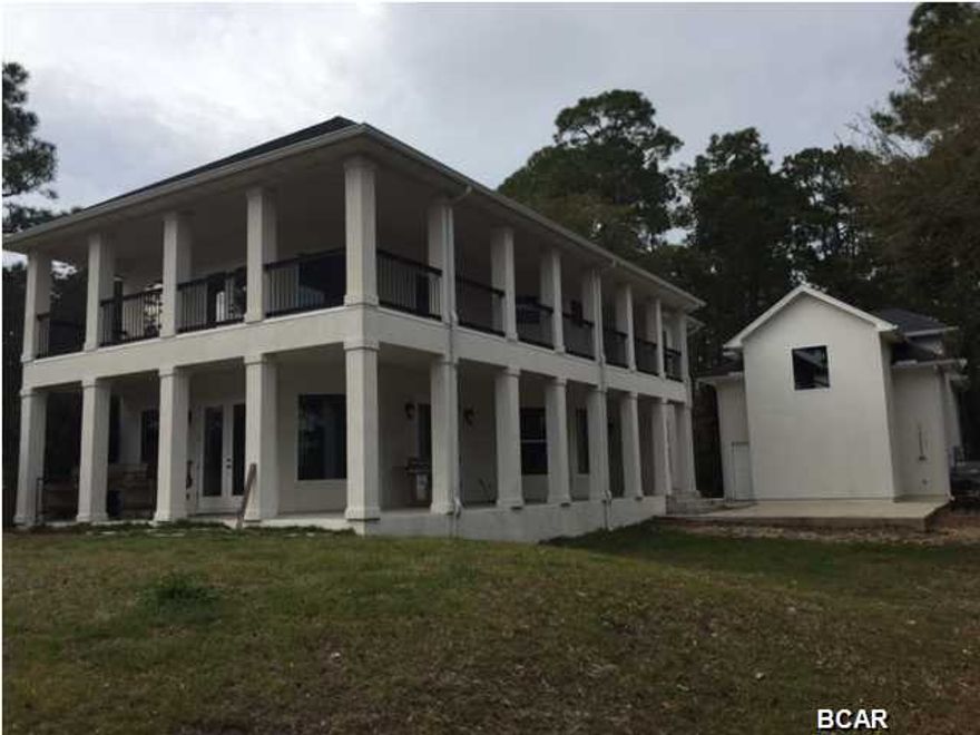 WATERFRONT FORECLOSURE YOU HAVE BEEN WAITING ON!!!!!!!!!!!!! Custom built high quality home on Fanning Bayou with a 1.7 acre lot and Boathouse with five ft. draft and a lift to accommodate a 10,000 lb. boat. This 3 or 4 bedroom home includes an efficiency guest suite over the detached garage and 4 large storage spaces. Living space in main house is 3 bedrooms plus a large office, and laundry room with cabinets and sink. Floors are dark rough sewn wide wood plank engineered flooring and an open floor plan with 12 ft. ceilings and lots of tall windows for natural light. The property has a with wrought iron fenced backyard and custom iron entry gate. Entrance drive is 900 ft long and lot is wooded along driveway for privacy. 110/220 Amps on the dock and running water. You won't find a  more unique and clean cut distinctive style home. Flood Zone A and insurance is only $500/yr as home is built up and compacted 3 blocks high with slab, and the Homeowners Insurance runs $2,000/yr approx.