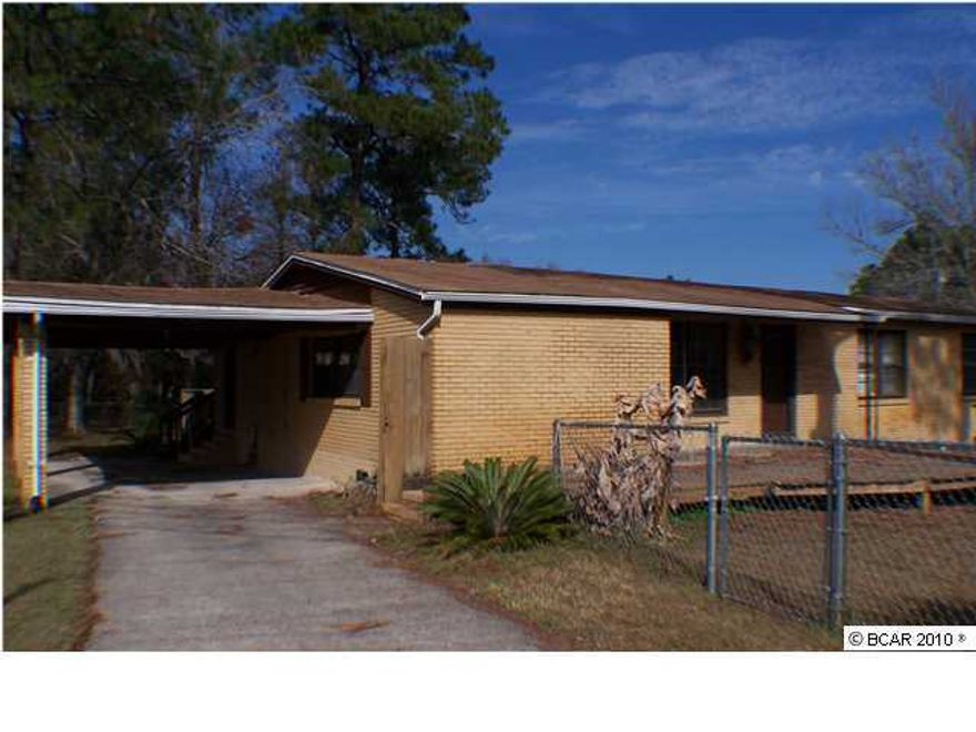 Convenient to everything! Brick, four bedroom, 2 bath home with separate working/outbuilding. Two large decks, fenced front and back yards, corner lot with driveway access in front and on the side, carport. Stainless Steel Stove and Refrigerator are less than four years old; hardwood flooring with carpet in some areas; separate laundry room.