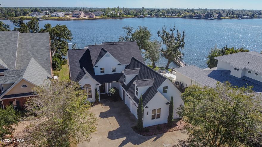 Experience Florida living at its finest in this stunning 4-bedroom, 3-bathroom bayfront estate offering over 4,000 square feet of refined coastal elegance. Thoughtfully designed for both relaxation and entertaining, this home showcases panoramic water views and an open, light-filled layout with expansive windows throughout.

The chef's kitchen is a showpiece—complete with a gas range, stainless steel top-of-the-line appliances, and an open flow to both the formal and informal dining areas. Just beyond, sliding glass doors fully retract to create a seamless transition from indoor living to the outdoor entertainment area, perfect for enjoying Gulf breezes and waterfront sunsets.

The main-level primary suite offers ease of access and ultimate comfort, featuring an attached office, a spacious walk-in closet, and a luxurious spa-style bathroom with a large glass shower and freestanding soaker tub. Upstairs, you'll find additional bedrooms, a full bathroom, and a bonus entertainment room with a wet bar, plus an optional theater or guest suite for flexible living.
The spacious garage provides dual garage doors plus a separate golf cart door, offering ample parking and storage for vehicles, recreational equipment, and coastal lifestyle essentials.

Outside, the elegantly landscaped lot leads to a private dock with deep-water access to the Gulf, ideal for boating enthusiasts. Located within the prestigious Panama Country Club, members enjoy access to a premier golf course, elegant clubhouse with a grill room for dining, pro shop and event center with social gatherings, along with a resort-style pool and pickleball courts and fitness center.

Close to top-rated schools, dining, shopping, and community parks, this home blends luxury, lifestyle, and location into one exceptional waterfront opportunity. Tour this one-of-a-kind estate and immerse yourself in the opportunities it holds.