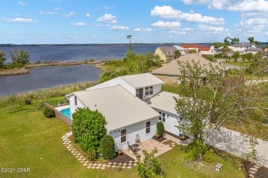 CURRENTLY UNDER CONTRACT, SELLER ACCEPTING BACKUP OFFERS. Want to live on the Water AND a Golf Course? Welcome to your new waterfront, golf-course community home with stunning views of both the Bayou and Bay, located in the Panama Country Club, a historic, 94-year-old golf course, situated in the heart of Lynn Haven, Florida.  This 4 Bedroom, 3.5 bathroom, Golf-Course Home is on a waterfront lot overlooking the Bayou, has a private pool, a bonus room on the second floor, and a first-floor mother-in-law suite, which can be accessed from either the main house, or a separate entrance.  There is plenty of room for everyone! You'll love this home's open-concept living with high volume ceilings, redesigned Master Bedroom, complete with a dream showroom closet and spa-inspired bathroom. The second master bedroom/mother-in-law suite, has a kitchenette, and overlooks the backyard pool and the Bayou and the Bay.  Both primary bedroom suites are located on the first level.  You'll love this home's tastefully updated kitchen, with all new appliances, granite countertops, a galley eat-in kitchen with a separate breakfast area. The home shows a newer roof, 2 HVAC's, and an electric fireplace in the main living area.  The upstairs bedroom has its own balcony overlooking the Golf Course, and the second floor also features a bonus room.  This home also has a large 2 car garage.  Relax and enjoy stunning sunsets over the Bayou from your private backyard pool, perfect for entertaining friends and family.  The neighborhood also has a community playground, and is convenient to shopping, boating, beaches, golf, parks and so much more.  This historic 94 year old golf course, has a POOL w/cabana bar on the BAY, which is now open, as well as a soon-to-be renovated clubhouse, which is available to use with a separate Panama Country Club membership. Call today to see this gorgeous home in person!