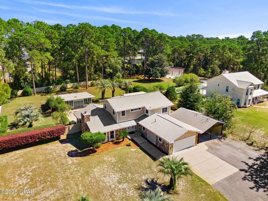 Experience the perfect blend of coastal comfort and country freedom on over an acre—just minutes from the beach. This spacious 4 BR | 3.5 BA multi‑level home delivers flexible living, inviting outdoor spaces, and room to spread out in a way that's nearly impossible to find in PCB. 

The main house is 2,500 sq ft and features Smart Home technology with video surveillance security system, smart lighting, door locks, and thermostats. The kitchen overlooks the pool and features granite countertops, tongue-and-groove wood ceiling, and a gas stove, opening up to a warm living room with a wood-burning fireplace. The main level includes two bedrooms and 1.5 baths, while the upper level features an office, a bonus reading/gaming room, and a private master suite with a sitting area, double closets, screened balcony, and ensuite bath with double vanities and a large walk-in shower. 

Step outside to your backyard retreat complete with an inground 60' pool, covered patio with hot tub and grilling area, pool house/mother-in-law suite with covered additional storage area behind it, and pole barn with 110 amp outlet. The pool house/apartment offers 560 square feet of heated/cooled space with a full bathroom and on-demand water heater. Ideal for creating an income producing rental, at-home office, or creating your newest hobby shop. Additional highlights include a two-car garage with storage room and large safe (included), plus a two-car carport. Located just 5 minutes from the Navy Base and 10 minutes from local restaurants, grocery stores, and beach accesses, this unique property offers the space, freedom, and lifestyle you've been looking for. 
*Seller Financing available. 
*All information and measurements approximate, please verify if important.