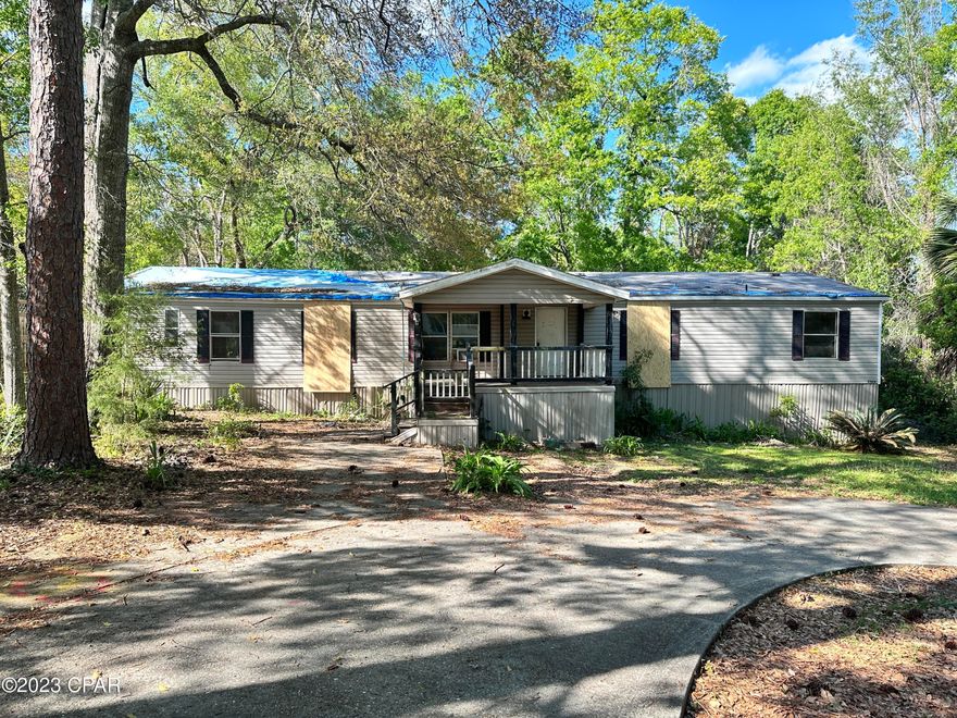 Large home with huge circular driveway on a spacious lot with a large workshop storage carport multi use structure. This home has very large master suite the master closet is as large as many bedrooms,  huge open living room and large kitchen. Amazing potential for someone that can bring skills to make improvements to this empty canvas. Close to town center of Bonify Hwy 79 that takes you to the beaches and I -!0 the gateway from JAcksonvile to LA! 5/17/23 there is a title issue with the mobile home that the bank is working on and it should be resolved in the next 4 weeks.