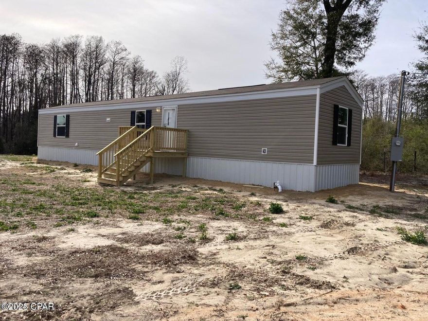 2023 Clayton Built, 14X66, 3 bedroom/2 bath single wide mobile home with porches and skirting sitting on 2.2 acres, set back off the highway in a rural area. It is Zone II rated for winds and is approximately 902 square feet. The Master bedroom/master bathroom is on one end of the home, and the other two bedrooms with a guest bathroom are on the opposite end.  There is a shared driveway (30 ft. deeded easement). This home is short drive to two public boat landings on the Choctawhatchee River. Survey available.