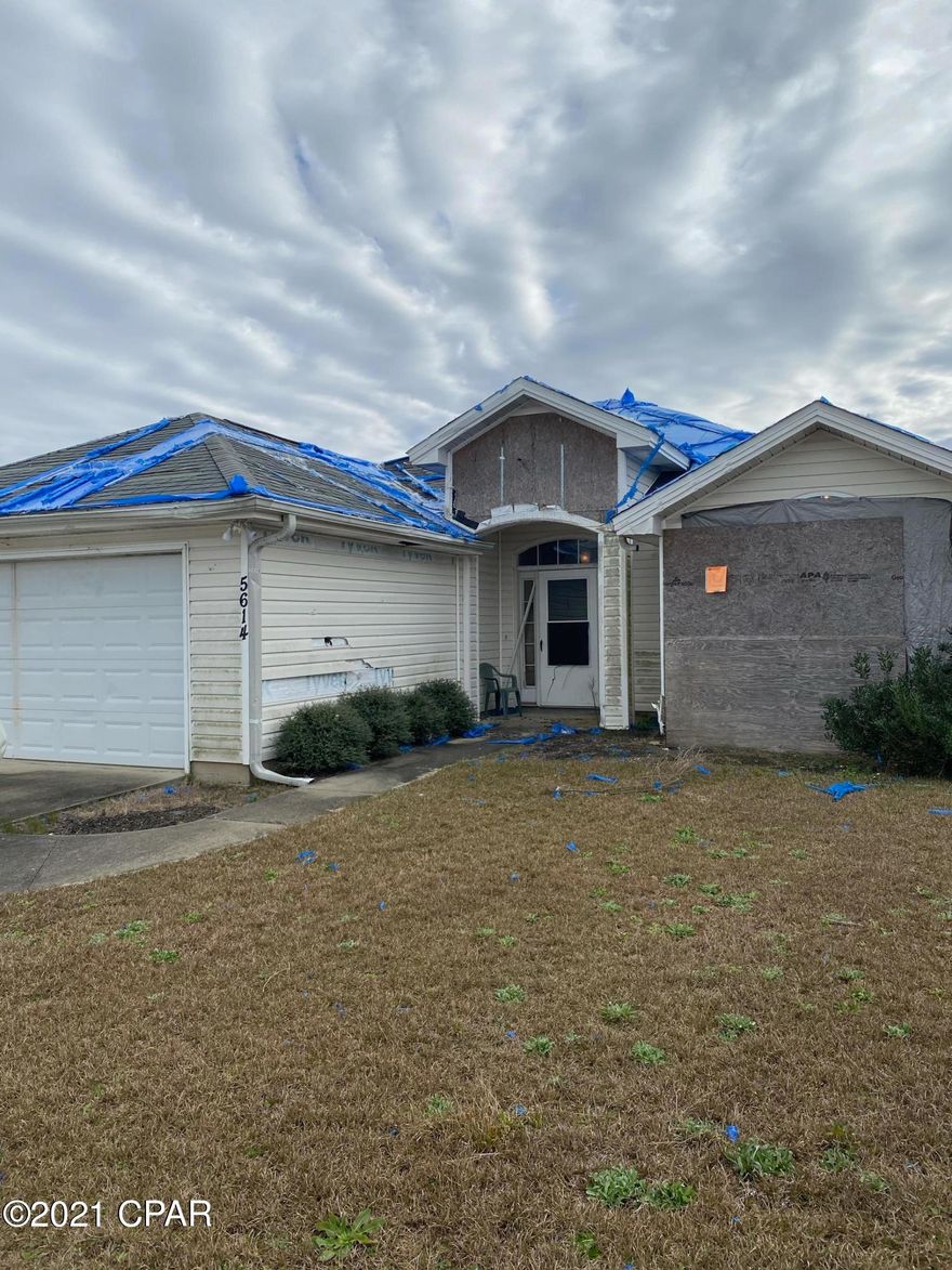 Damaged home in need of roof, siding, and minor interior remediation.