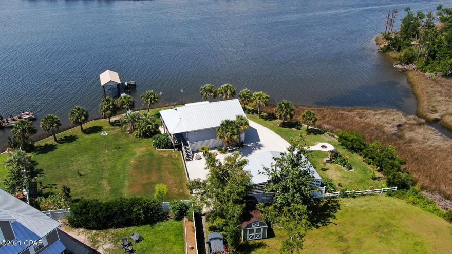 CURRENTLY UNDER CONTRACT, SELLER ACCEPTING BACKUP OFFERS Gorgeous waterfront home that's as close to paradise as you can get. As you arrive you are greeted with beautiful landscaping and a breathtaking view of the deep waters of Cook Bayou and East Bay. Entering the home you will immediate notice the bright open floor plan of the living room, kitchen and dining room. The soft wall colors, natural light and beautiful tongue in groove ceilings create a relaxing I'm home feeling. Prepare your meals in the beautiful as well as functional kitchen while admiring your waterfront view. The large master bedroom has sliding glass doors that lead out to your balcony on one end and a Spa like bathroom with glass walls, double vanity, and tiled shower on the either of two screened in porches. Leading out the deep water is a well-built composite wood dock and covered boat lift with electric motors. End your day relaxing on the custom-built bench at the end of the dock watching the dolphins play and birds feed as the sun sets. Every upgrade in this home was carefully thought out and designed for efficiency, functionality, and energy savings from the seamed metal roof to the Bosch air conditioning system. Large oversized work shop with electricity and a lean-to on both sides is great for the hobbyist, craft enthusiast or gardener. If you're looking for a place to escape the crazies of city life, a quiet peaceful retirement home or a secure area to park your boat this is the home for you. Contact your favorite Realtor today to view this beautiful move in ready home. All measurements are approximate so please verify if that's important.