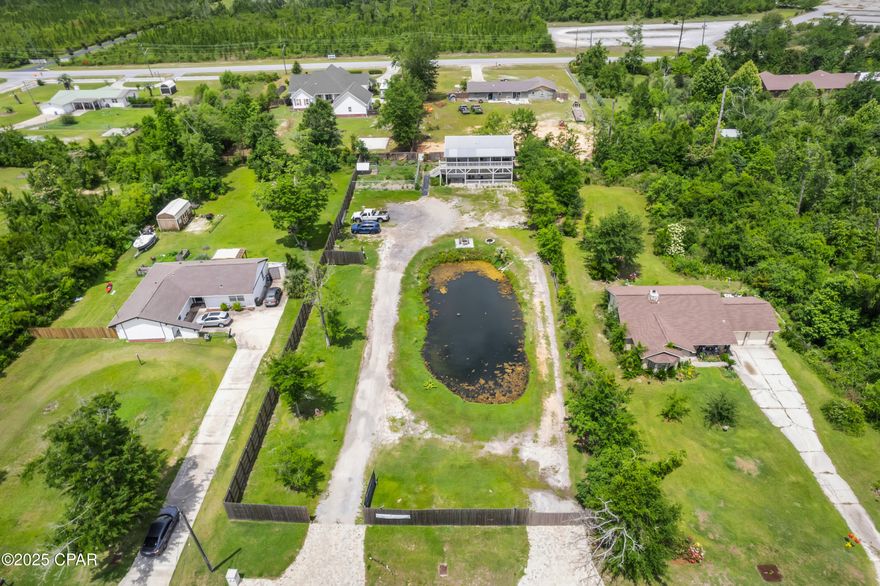 ROOM TO GROW. ROOM TO GARDEN. ROOM FOR WHAT'S NEXT. 
Located just north of Highway 231 near the intersection of Transmitter Road and Highway 390, this versatile two-story home offers nearly an acre of land—including a private pond—in a convenient Panama City location just minutes from the Lynn Haven Sports Complex and everything the city has to offer. Upstairs, you'll find three bedrooms and two full bathrooms with LVP flooring in the main living areas and carpet in the bedrooms. The kitchen features a tile backsplash, and both bathrooms have fully tiled showers that add a clean finish. Step outside to the large upstairs balcony that spans the front of the home—perfect for sipping morning coffee or unwinding with a cool evening breeze while taking in views of the pond and surrounding property. Downstairs includes a half bath, a one-car garage, and a spacious open area with two additional rooms that could easily be finished as bedrooms—ideal for creating a private rental suite, home office, or multigenerational living space. The property is fully fenced and ready for your outdoor lifestyle, with ample parking, a chicken coop, and a productive garden already planted with vegetables and sunflowers. Major upgrades include a metal roof installed in 2020, new HVAC system in 2018, and Hardie board siding for added durability. Property is located on Flood Zone X. If you're looking for space, flexibility, and the freedom to shape your future—4331 Garrison Road offers it all, just minutes from town. 

All information is deemed reliable but not guaranteed. Buyers should verify any details that are important to them.