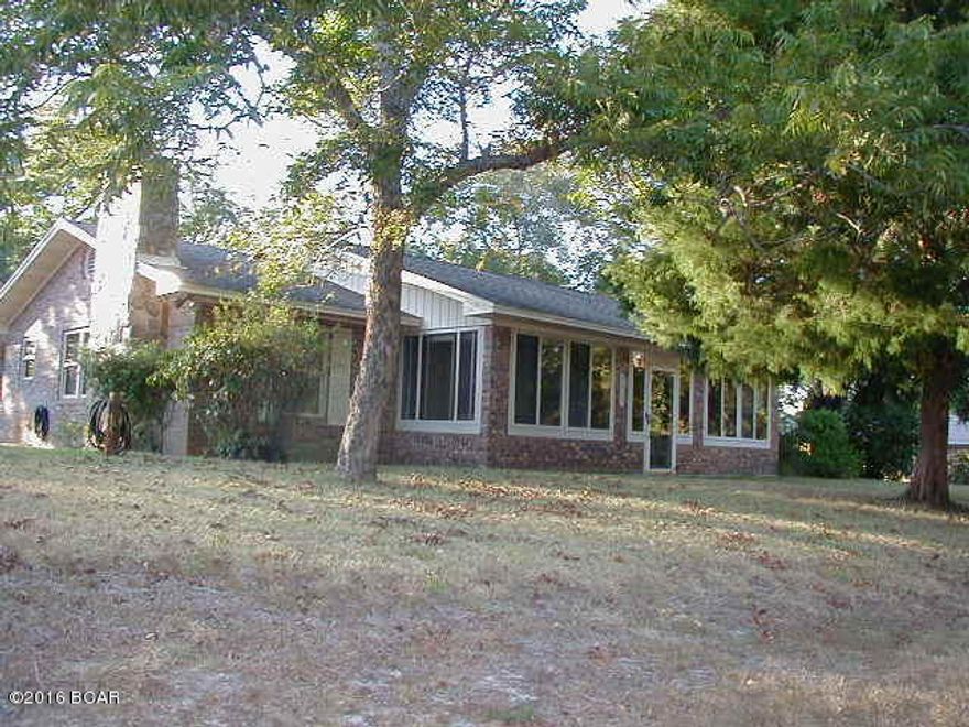 Brick, one owner home in a convenient quiet area.  Very near the Pretty Bayou boat ramp.  Updated kitchen with breakfast room and lots of built-in cabinets. Cozy den with fireplace, large enclosed front porch (FL room) with ceiling fans, very large dining room, large utility room plus another room I am calling storage on room sizes. Also small screened back porch with windows too and covered patio off the master bdrm. New heat pump, roof replaced 2008. 20x24 outside building which is storage but could be garage as there is a driveway.  Sq ft, room sizes, ages, etc. are estimates, please verify if necessary.