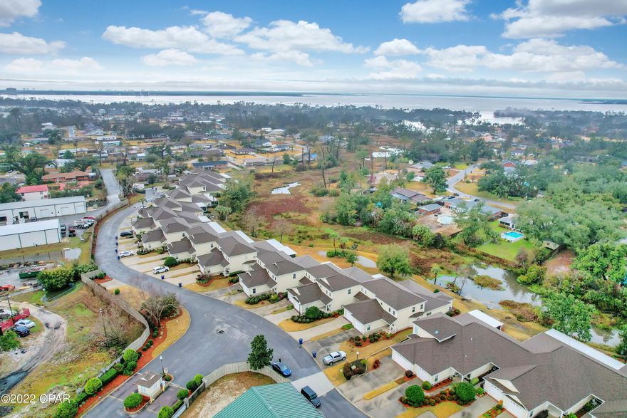 This immaculate townhome is in a gated community that is perfectly located! It's just a short drive to the beaches, Pier Park, St. Andrews, downtown P.C. and all that Bay County has to offer! This home is inviting and has a spacious custom kitchen w breakfast bar open to the dining and living room. The enclosed sunroom overlooks Hentz Lake and is unique to this property giving yet another option for a study or playroom.  The master bedroom is downstairs with an ensuite master bath that includes a separate bath and shower and two custom designed vanities and his/hers closets. The bonus area and two additional bedrooms and ensuite bath are upstairs. The laundry room has a sink and cabinets and the washer and dryer convey! Schedule your showing today , this property won't last long!