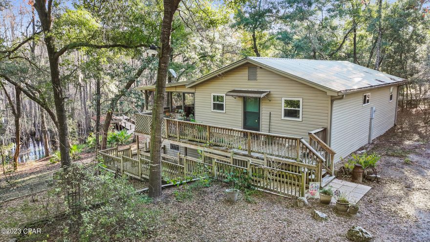 WATERFRONT and on a paved road!! Desirable waterfront home located on Lake Martin just outside of Chipley and about 30 minutes to the world's most beautiful beaches. If you are looking for seclusion, nature, fishing, quiet, privacy, and relaxation this spot is for you! Enjoy a hot cup of coffee or iced tea while sitting on the screened in back porch that overlooks the lake. Below you will also be able to enjoy a multi-purposeful room that is encased in windows all around and could be the spot for endless opportunities or to just enjoy the backyard view!  All windows have been replaced, new HVAC system, private dock and boat slip, brand new walk-in shower completed by Bath Fitters, and located on just over an acre of land. Come see why you should call this place home!