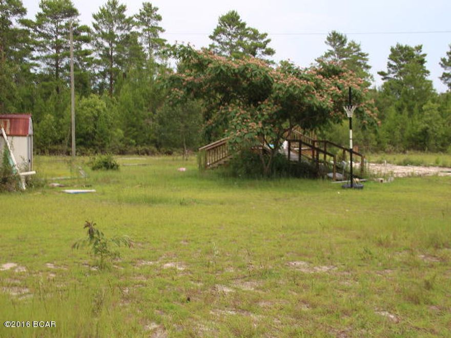 1.56 acres of vacant land with a septic tank and well with missing pump. Previously there was a mobile home on the lot. It is a nice lot just right for a mobile home or a house to be built on. It has a paved driveway and a yard building.