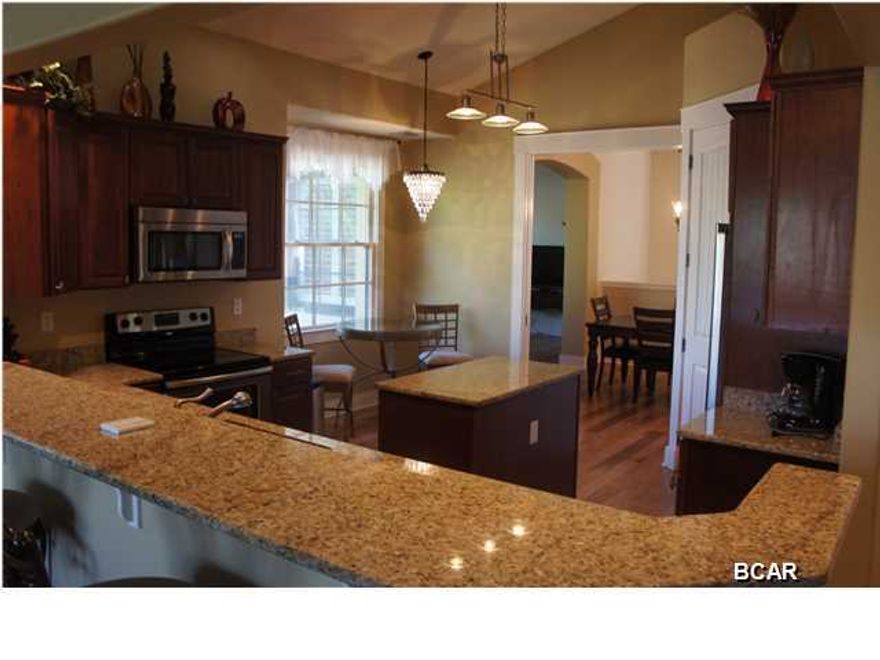 Truly unique opportunity that is rarely available. This is the largest condominium unit available in Clubside II boasting 3,076 heated/cooled square feet. Also, this is the only unit opening up to a 1/3 acre side yard that is completely maintained by the condominium association. This three bedroom / three bathroom, fully furnished home is meticulously maintained by the current owners and only the finest materials were used during construction. Custom hardwood floors greet you in the foyer area and are featured throughout the living, dining, and kitchen areas. The bathrooms come with 20'' tile floors and the bedrooms have plush carpet. The dream kitchen has stainless steel appliances, granite countertops, breakfast bar and island, tiled backsplash, pullout wood cabinets, gigantic pantry, recessed lighting, and a separate breakfast nook. The kitchen opens up to a spacious living room with views of the Golf Course. The master bedroom is privately located off the main living area with his and hers walk-in closets and a bathroom that rivals Rosemary Beach's finest homes. The master bathroom is absolutely breathtaking with tile floors, granite countertops, double vanity, jetted garden tub, and a separate walk-in shower with custom tile. There are two guest bedrooms with their own private bathroom. The first guest bedroom currently serves as an entertainment room with a pool table. The second guest bedroom overlooks the pavestone driveway and private entrance. The laundry room comes equipped with top-of-the-line washer/dryer, ample storage, and a separate closet houses the electric water heater and HVAC handler. Just a few extra features of this home are: open floor plan, raised ceilings, screened-in patio with hurricane resistant doors and golf course views, premium furniture including bookshelves and entertainment center, flat screen televisions, plantation shutters, and custom window treatments. Wild Heron does not allow short term rentals which adds to the communities privacy and enables this condo to feel more like a home. Wild Heron's unique architectural style is apparent in each residence and community structure with a focus on natural finishes like slate, river rock, split stone, glass, wood and metal. A series of walkways links various areas of the community including a boardwalk & dock to Lake Powell, a Boat House Pavilion at Prospect Point with kayaks and canoes, lake front pool & hot tub, kiddie pool, outdoor fire pit & grilling area, nature trails, a community gazebo & playground, oak-filled park, fitness center, and renowned Greg Norman-designed Shark's Tooth Golf Club. There are limited golf memberships still available for the club. The quiet setting of Wild Heron is only minutes from the Gulf of Mexico and is bordered by Walton and Bay counties. Conveniently located to Scenic Hwy. 30-A (to the west), Pier Park (to the east) and within 30 min. of the Northwest Florida Beaches International Airport. Do not miss out on this incredible opportunity to own at one of Panama City's finest developments.