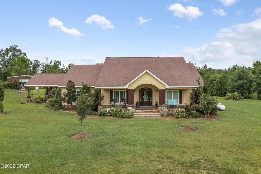 Location, Location, Location! This stunning 3-bedroom, 2.5 bath custom home is secluded on 20+/- luscious acres directly off Piney Grove Road! Step inside and you are immediately greeted with an inviting foyer, beautiful crown molding, ½ bath, living room with gas fireplace that is open to the spacious eat-in kitchen boasting custom cabinetry, island, breakfast bar, granite countertops, double oven and copper hammered sink.  Slip away to your master suite featuring a gas fireplace, double vanity, massive walk-in closet and direct access to the back porch. Other inside features include 2 guest bedrooms, full bath, laundry room with sink and office. Outside you will find covered front and back porches, attached carport, paved driveway, luscious landscaping, stocked pond, 50x40 enclosed steel building and a 36x24 open barn. Property is located minutes from schools, shopping and Interstate 10.