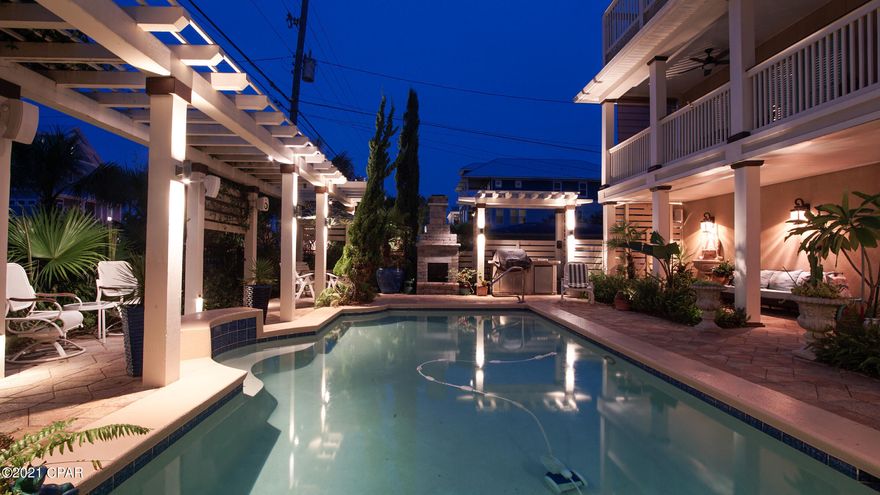 CURRENTLY UNDER CONTRACT, SELLER ACCEPTING BACKUP OFFERS' Spectacular pool house located directly across from beach access point 89. This home faces Front Beach Road on the corner of Derondo Street. Enjoy fabulous Gulf views from the 2nd and 3rd floors, which include all main living areas and 3 of the 4 bedrooms. This tropical paradise has it all- lush landscaping including Sylvester and  Cabbage palms, a beautifully styled pool and entertaining area, an outdoor kitchen with a grill and refrigerator, a beautiful stone fireplace, plenty of space for multiple seating and eating areas, custom crafted arbors and special effects lighting, even 12 stereo speakers for listening to your favorite music, all providing a fantastic venue for entertaining or just relaxing. . And enveloping it all is a beautiful custom wooden fence for privacy. Imagine the lifestyle you can enjoy-grilling by the pool and sipping margaritas with family and friends and then walking a few steps to lay on the beach and soak up some rays.  Tucked away on the west  side of the house is an additional sitting area with Zen ambiance, shaded by a canopy of  tropical trees. What a great hideout when you just need some quiet time! There's no shortage of parking for this beach house with a 2 car garage plus extra space for four more vehicles. The home has 2 master suites, one on the ground floor and one on the third floor. The ground floor has a spacious, private suite including a bedroom and bathroom, which can be used as the master suite or for visiting family, extended live-in or as a potential rental. The master on third floor has a morning bar . The kitchen equipped with an island and stainless steel appliances, including a 42 inch Kenmore Elite smooth top range, all open to the spacious dining room and living room. The floors in the living room, kitchen and dining room are luxury vinyl plank.  Also located on the second floor is a half bath and spacious laundry room. The third floor has a sitting area, another master suite and two other bedrooms each with its own  balcony offering stupendous Gulf views. If you want a great beach house that has it all and more without the hassle of an HOA, look no further! The pool is saltwater, there are two heat pump AC units one unit brand new the other about 2 years old. The home also has two renai tankless units powered by natural gas (Teco). So natural gas is available if someone desired to heat the pool.