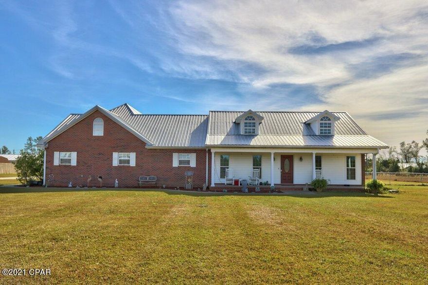 One of a kind home with acreage in Northwest Florida.  This home comes fully furnished with everything you could want in a large family home with room for your out of town guests.  The main house features a columned dining room and a living room with vaulted ceilings.  The master bedroom in this split plan home is large at 21' by about 19' with dual vanities in the bathroom.  The kitchen has an abundance of cabinets and leads into the utility room that has even more storage space.  Upstairs you will find a bonus family room that leads into a spectacular theater room.  The theater room comes completely furnished with a3-D overhead projector, 6 deluxe reclining theater seats, 7.1 surround sound speakers and even sound reducing wall coverings!  Behind the main house you will find a good sized building that gives you the option of keeping it as a large game room with a separate meeting room that features a kitchenette and half bath or converting into a guest house.  Above the game room and meeting room you will find even more storage space.  The east side of the building has enclosed storage for you lawn equipment and other tools.  Outside brings even more great features. The front yard has a 6 zone sprinkler system which you can control with your smart phone.  There is a large carport awaiting your RV or camper on the east side of the main house.  The back yard is fenced for your pets and you can enjoy watching from the comfort of the screened back porch.  There is a whole home security system in place and the front gate is automated.  The main house has a 4 zone CHA system to reduce your electric bills.  The metal roof and plank floors are just a couple of years old. The home is located a short 15 minute drive from I-10 in Marianna and only one hour from either the Tallahassee International Airport or the Northwest Florida Beaches International Airport.  Don't miss out on this one!