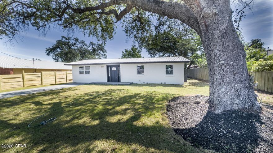 Discover this beautifully updated home in the heart of historic St. Andrews, perfectly positioned on a spacious lot shaded by majestic heritage oak trees. Just steps away from waterfront dining, the marina, boutique shops, parks, and vibrant local amenities, this home offers the ultimate blend of classic coastal charm and modern convenience in one of Panama City's most desirable neighborhoods.

Arrive via a handsome paver driveway to a welcoming front porch featuring fresh paint, all-new windows, and a striking custom front door. The durable concrete block construction and  metal roof ensure long-term peace of mind, while the location means no flood insurance is required.

Step inside to an impressive open-concept living area anchored by a cozy electric fireplace with custom accent surround. The brand-new modern kitchen features a large breakfast bar that overlooks the living and dining spaces, creating a perfect flow for entertaining and everyday living. All-new luxury vinyl plank flooring runs throughout the home, complemented by modern LED recessed lighting with soft halo backlighting and upgraded fixtures for a bright, contemporary feel. A convenient walk-in utility room offers backyard access and connects to a small private patio--ideal for morning coffee or outdoor grilling.

The thoughtful split-bedroom floor plan delivers privacy and comfort. The spacious primary suite features dual closets and a luxurious walk-in shower. Two additional guest bedrooms share a well-appointed bathroom conveniently located just off the living area.

A large, fully fenced backyard is a true highlight--offering plenty of room for a future pool, playground equipment, boat/RV parking, or simply relaxing under the oaks. A storage shed is included for added convenience.
This home lives like new thanks to a comprehensive list of updates including: all-new appliances, new air conditioning system, new attic insulation, lighting and plumbing fixtures, windows, doors, paint, floors, and more. 

Whether you're looking for a primary residence, vacation home, or investment property, this move-in-ready gem delivers classic St. Andrews character with today's modern amenities and low-maintenance living. Enjoy easy access to everything Panama City, St. Andrews, and Panama City Beach have to offer--beaches, boating, dining, and more. Don't miss your opportunity to own this rare find in one of Panama City's most charming waterfront communities.