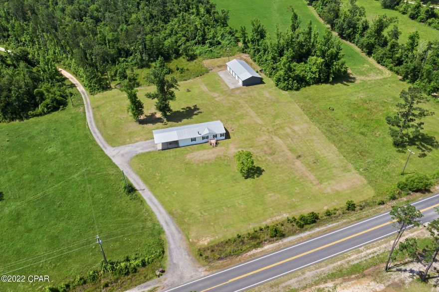 Country living!  Double wide mobile home situated on 3.12 acres.  Home features an open concept in the living room and dining area. 

 Three bedrooms situated in a split bedroom floor plan.  Property features a 30x70 outbuilding with concrete and electric (and its own separate meter).  Outbuilding has bays with roll up doors. There is also two wells.  Home is located on a paved road.
