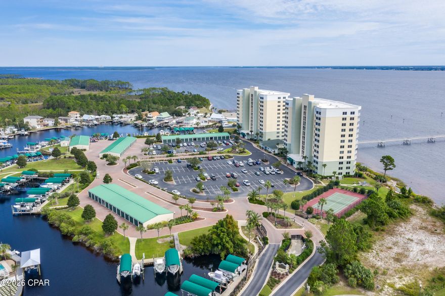 The BEST in Waterfront Living: This beautiful community includes boat slips and garages for sale or rent, jet ski slips, over 400' fishing pier, grilling stations, tennis basketball or pickleball court, fire pit, and a walkway/stairs into the gulf for your paddle board or kayak, plus much more! Step inside this amazing condo and you will immediately notice the over $70K in upgrades: extra security French doors in the foyer for safety also to ensure a pet  won't dart out; Remote controlled hurricane shutters on the water side; custom made room darkening shade; insulated draperies, plantation shutters; Custom 3/4'' all wood shaker cabinets in kitchen with quartz countertops- including slide-out shelves in all bases; Stainless steel appliances with electric cooktop and built-in oven & microwave; built in 3 door refrigerator; dishwasher with 3 sliding shelves; Farmhouse double sink; Pendant lights; Newer HVAC with hepa filter & heat pump with networked programmable thermostat; Water heater replaced; Custom trim and wainscoting; Whole house surge protector and Water filter; Stackable Washer/Dryer, pantry and storage area in kitchen area.  The large primary bedroom features trey ceiling; new sliders with a spectacular view of the sunrise on the bay and ensuite with double vanities and quartz counter tops; separate venetian marble shower; garden tub with tile surround and spacious closet with built-ins. The Great Room features the new hurricane rated sliders with another fabulous view of the bay. The secondary bedroom features a spacious closet; plantation shutters and a full bath with large shower just steps away! This amazing home also features LVP flooring throughout; and fresh, custom paint. The community completed the Structural Integrity Study and invested millions in improvements with no extra costs to the residents. The buildings have been completely resurfaced and repainted including the walk ways. The amenities also include a work out gym, community room for parties/get togethers, and a peaceful library for working or reading at no extra cost to residents.  The no short term rentals make this community a more relaxed/serene lifestyle with an atmosphere of unity and long term friendships. The HOA includes water, garbage, pest control, high speed internet with over 200+ tv channels, gated entrance and cameras for security.  If the amenities and welcoming atmosphere don't draw you in - the awesome sunrises and water life will - including dolphin, redfish and mullet.  It is truly an exceptional place to live!