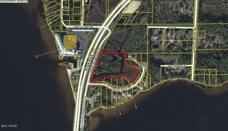 This FABULOUS WATERFRONT/VIEW LOCATION is just across Bailey Bridge on Hwy 77 in Southport. The large, commercial zoned parcel sits just off the old House of Seafood Drive with beautiful views of North Bay. Just off highly travelled Hwy 77, across from Marina Bay Condos  and just minutes from the new Panama City Airport, this parcel could be used for commercial  or residential projects.  There is approximately  1.5 acres of buildable commercial land and 3 acres of wetlands with a small pond. Property has been cleared of undergrowth .