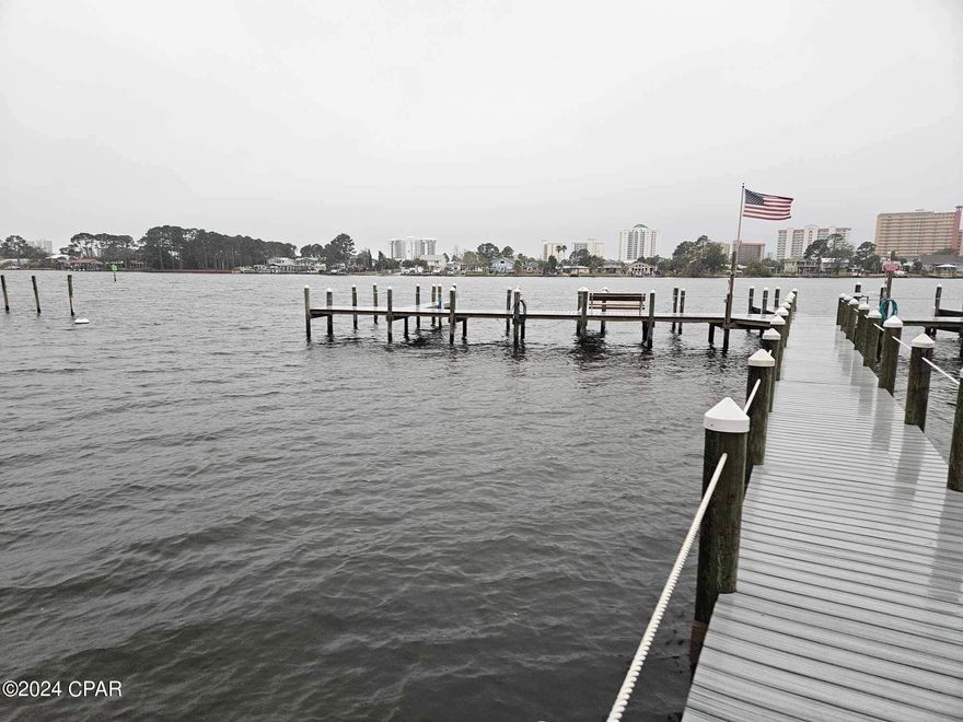 This simple condo is ready for your vacation get away! With plenty of parking and a dock available you can be on Shell Island in no time!  Unit has tile floors, full size washer/dryer and a view of the tennis courts.  The large pool is just steps away from your back patio.  HOA fees include trash, water, pest control and clubhouse.  The complex offers a dock, available boat slips, and a fishing area. Short Term Rentals are allowed, at least 30 days as of January 2024 HOA. Boat slips are available to rent for $150 a month with a one year contract