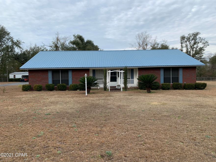 Nice brick house 3Bedroom/2 bath with over 2,100 sqft with split floor plan.  Home features a new metal roof. AC unit 2 years old. Single car carport with screened in back porch. Outbuilding with 2 car carport. 1 acre lot is completely fenced with chain link fence. House can be purchased furnished or unfurnished.
