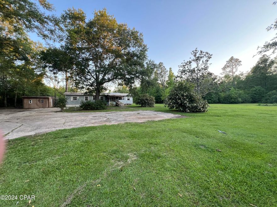 An amazing 3.83 acre parcel with a 3/2 mobile home. Excellent location. Property has a wooded perimeter and feels very private. Paved road. Home needs to be rehabbed. There is also a metal workshop with double doors. Plenty of potential for the right buyer. Cash offers only.