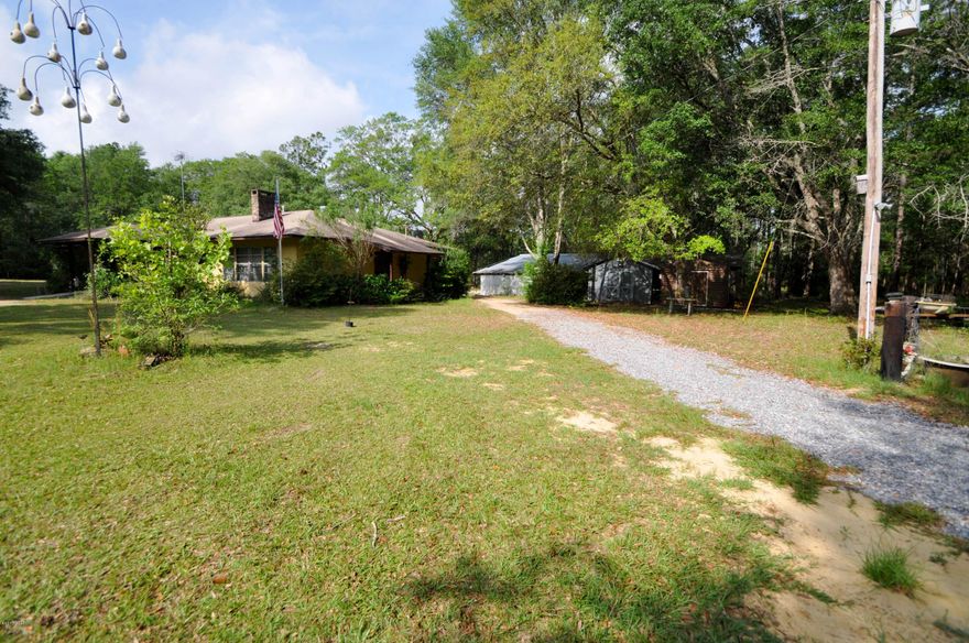 What a find. 10 acres just off I-10 and by downtown. Nice mix of cleared and timbered land with a pond. Plenty of room if you want horses cows chicken goats... House is snuggled under the trees.2 huge Master bedrooms...all the rooms are large. Great place to have a huge garden. You have 2 storage shed and a huge 36x48 barn building.  This is 2 parcels PID#	1010.00-000-000-013.000 and PID#  1010.00-000-000-005.000  for a total of over 10 acres..This All sizes are approximate, please measure if important.