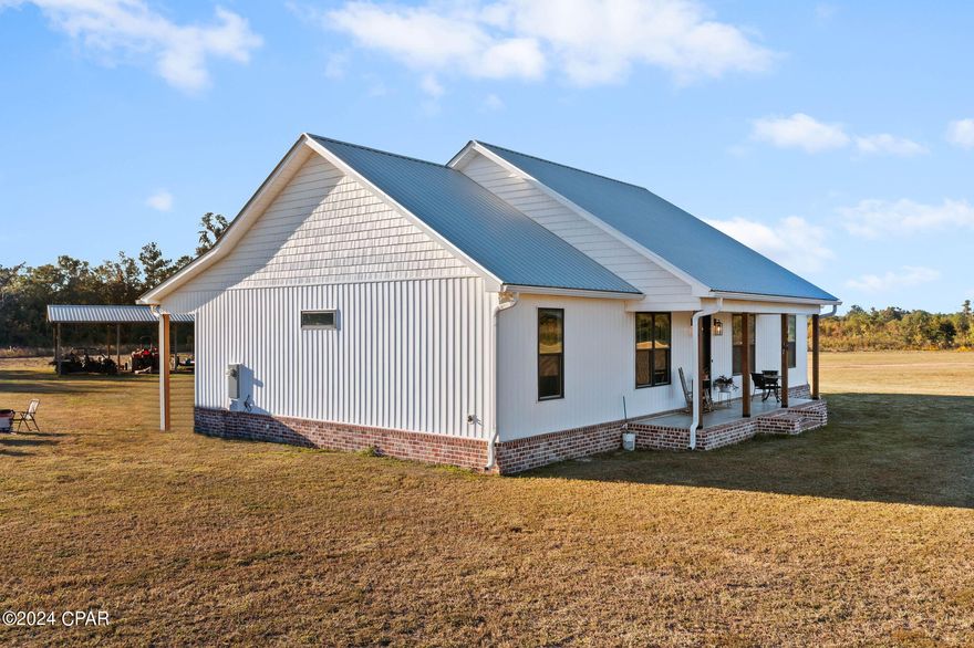 Welcome to your serene countryside oasis! As you arrive at this picturesque property, the grandeur of the sprawling oak trees sets the tone for the tranquility that awaits. Nestled within this idyllic 19.65 acre setting is a charming 2023 farm house, exuding timeless allure and old-world Florida charm. Step inside this well thought out country home, where you'll discover a split floor plan featuring 3 bedrooms, 2 bathrooms, and an inviting open floor plan characterized by vaulted ceilings. The centerpiece of the living space is a majestic electric fireplace adorned with floor-to-ceiling shiplap, creating a cozy ambiance that's perfect for relaxing evenings. Additionally, this homes double rear entrances provide a space for guests to come and go through glassed french doors that enter into the dining space when entertaining or into the back mudroom with large walk-in laundry as well as separate large walk-in pantry. Also featured inside is the custom cabinetry and kitchen island, complete with your very own wine fridge. Venturing outside, you'll encounter sprawling porches on both the front and rear of the home. The front porch is the perfect place to enjoy a morning cup of coffee while enjoying the spectacular sunrises and the back porch for sipping that glass of wine while you watch those endless sunsets unfold. If hunting is your thing, you can certainly do that here as the partial wetland in the back area of property attract deer and ducks. Or if being self-sustaining appeals to you, plenty of room for your own garden, cows, chickens or horses. Miles and miles of scenic dirt roads on which to ride your horse. Completing the property is a practical pole barn, offering convenient storage space for outdoor equipment or vehicles. Imagine spending leisurely evenings on the back porch, sipping sweet tea, and marveling at the abundant wildlife that frequents the area. With the town of Chipley and all it's conveniences just a short drive away, you can have the best of both worlds! Don't let this opportunity for quiet country living pass you by. Embrace the serene ambiance, embrace the charm of this well thought out farm home, and unlock the potential of the sprawling acreage. Whether you're seeking a peaceful retreat or a place to call your forever home, this one is sure to fit the bill!