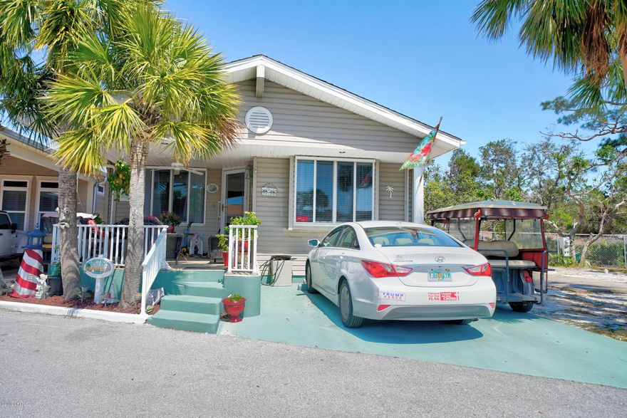 Don't miss out on this rare opportunity to own a Venture Out home that backs up to St. Andrews State Park. This beautiful 2 bedroom, 2 bath home has large rooms and flows beautifully. The home has just had the interior repainted and has new flooring. It also has a new hot water heater and new pavers around the back deck.  This best part of all is the stunning views of St. Andrew's State Park.  Did I mention the front porch?.... Well it's absolutely AMAZING!! Just bring your swimsuit and get ready to relax. Venture Out  has 300' on the beautiful pristine beaches of the Gulf of Mexico and 1,000' on the Grand Lagoon. Venture Out has something for everyone. With  pools (one heated), fishing pier, boat ramp, mini golf, children's play ground and much more.