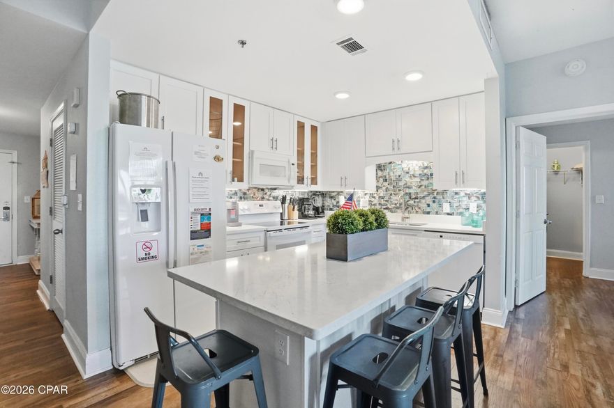 This exceptional first-floor residence offers the best of both worlds: calm lake views and easy access, all without the wait or hassle of elevators. From the moment you step inside, the coastal design and sophistication set this unit apart.

The beautifully updated kitchen is a true showpiece, featuring crisp cabinetry, upgraded countertops, modern appliances, and a striking turquoise backsplash bringing the Gulf's colors indoors. The open-concept living and dining space is light-filled and inviting—perfect for entertaining or unwinding after a day at the beach.

This unit offers two spacious bedrooms plus a stylish bunk room, ideal for guests or family. With the addition of a barn door, the bunk room easily functions as a third bedroom offering privacy, adding flexibility and value. The primary suite is a peaceful retreat, positioned directly on the lake with soothing water views that make mornings and evenings feel extra special.

Step out onto the large private balcony spanning the width of the unit to enjoy lake life and take in the nightly light show, visible both outdoors and from the comfort of the living area inside.

Beautiful design touches flow throughout the home, blending coastal charm with modern comfort. From the furnishings to the finishes, every detail reflects the essence of the perfect beach getaway.

Whether used as a primary residence, second home, or investment property, this first-floor unit with water views is a rare opportunity—where beauty, convenience, and coastal elegance come together seamlessly.

As part of a large resort, you'll have access to world-class amenities, including the newest addition of 810 Billiards & Bowling as fun for the whole family on property, five pools (one zero-entry, heated, and a dedicated kiddie pool), two hot tubs, a state-of-the-art fitness center, and a putting green. Enjoy the convenience of multiple onsite dining options and a boardwalk that showcases a stunning nightly water fountain light show. Don't miss this opportunity to own a piece of paradise with solid rental returns and endless coastal charm! All measurements to be verified by buyer if deemed important.