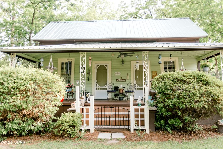 MOVE IN READY and SEMI-FURNISHED! 2 or 3 bedroom/2 bath home! Classic Craftsman Charmer with tons of character on a large shady .45 acre in the city limits of Bonifay. Home features custom, creative updates within past 4 yrs to include new exterior paint, new metal roof (2021), vinyl plank tiles in kitchen, new laminate, restored original hardwoods in living room, custom trim work, new fridge & stove (2019), HVAC (2019), PEX plumbing (2021), new 200 AMP service & electrical panel (2019). Ceilings boast wood & copper colored tin custom accents in living room! This home portrays a southern vintage farmhouse vibe with old world touches and has been meticulously kept! The kitchen cabinets have been refurbished and granite countertops added. Bathrooms have been updated. The home has been partitioned off to create a separate apartment or MIL suite with exterior door. ThIs partitioned area has a mini kitchen, living room, bedroom, bathroom, and laundry room and could serve as income producing if rented. However, if desired, home can easily be converted back to a single space (via interior door access) and reconfigured to allow for 3 bedrooms if desired. Two outbuildings with electricity convey (neat as a pin) for all your storage & workshop needs.  Also, there is an outdoor shower, fire pit with wooden swing & picnic table, and a nice size carport with concrete driveway. 30 AMP RV hookup behind house.  This home comes partly furnished and two washer/dryer sets (2019 & 2022) convey.