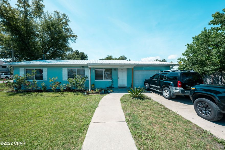 Adorable cottage on a completely fenced corner lot.  Solid concrete block walls, metal roof, and tile floors throughout make this home low maintenance with peace of mind.  The garage would make a great workshop or storage area if you did not want to park car.  Seller will provide new stove and microwave with purchase. Home is currently rented for 1400 a month.
