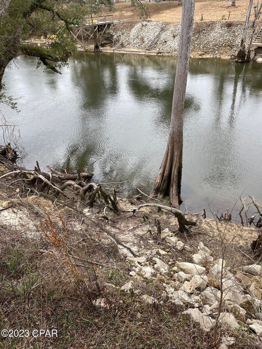 $139,000. SALE PENDING!  Enjoy the peaceful beauty of the pristine Chipola River! Sit on or fish right from your dock, watch canoers as they drift by, or just enjoy the evening air and sunsets over the river. The dock, the cookhouse beside the river, and also the bathroom building, haven't been used in a long time so they all need clean-up and some repairs. This almost 2-acre parcel already has a well, septic, and electricity. The owner also installed 3 water and electricity hook-ups for visiting guests or RV's. Build a permanent dwelling or a getaway place on this level, cleared piece of ground. If you want to be right on the beautiful Chipola River, this may be just the spot you've been looking for! $139,000.