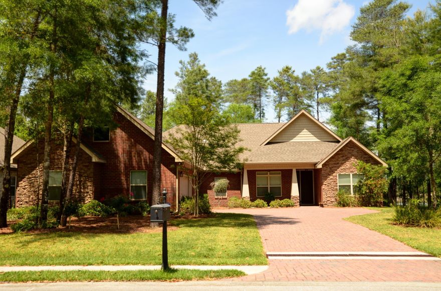 Gorgeous home nestled among the trees in Lynn Haven's highly sought-after, gated community, Grant's Mill.  Beautiful hardwood floors, 9 ft. ceilings, and elegant crown-molding adorn the entry way and dining room.  An 11 ft. stepped to 13 ft. tall trey ceiling in the open-concept living room gives the home a spacious feel while the gas log fireplace brings about coziness.  The kitchen, breakfast nook, and bathrooms contain tile with carpet in the bedrooms.  Stainless appliances, granite counters, and custom cabinets round out the kitchen.  Each of the three bathrooms contain the same custom cabinetry and granite counters as the kitchen.  This home is well-suited for a large family with two bedrooms on one side of the house, and the master and two other bedrooms on the other side. The elegant master bath and large master walk-in closet separate the master suite from the other two bedrooms.  Above the garage is a large bonus room with ample attic storage.  Additional features include: spacious laundry room with sink, tankless hot water heater, large 2-car garage with overhead storage and side shelving, exterior security lights, sprinkler system with separate irrigation meter, low-energy windows, security system, and two A/C units.  All this plus a fantastic neighborhood.  1% buyer fee.  All ages, sizes including sq. ft. are approx. please measure if important.