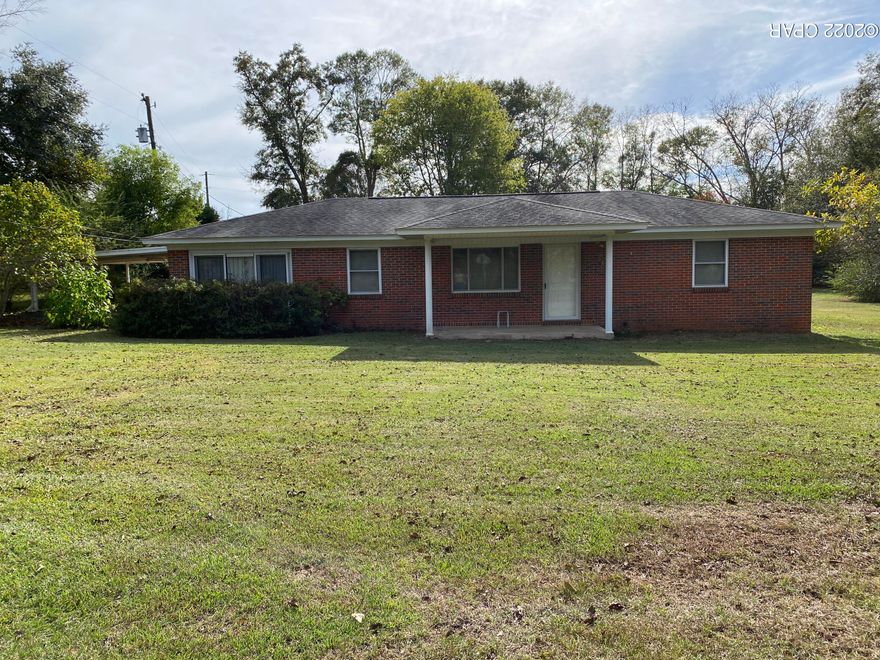 Traditional 2 bedroom/2 bath ranch style brick home on concrete slab with central heating/cooling just waiting for your own personal updates! Two living rooms and two dining areas allow the possibility for a third bedroom with some creative innovation.  House features a two car carport and a screened-in back porch. Laundry/mudroom just inside the back door.  Large 2 acre parcel with highway frontage adds additional appeal!