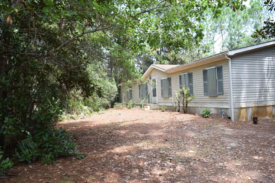 Corner lot across from East Bay!  2 acres of wooded land for privacy. Clear the trees and have a Bay view. On well and septic, but public water & sewage available.  Heat pump 2 years old.  Huge 24'x24' workshop. Carport with concrete slab. Great deal on a mobile home. Call before it's gone!