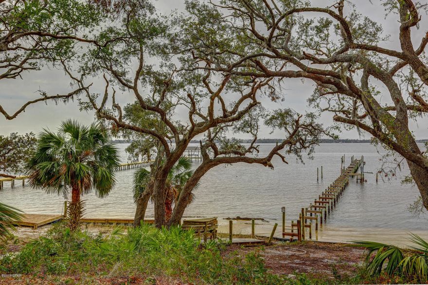 This traditional all brick 4 bedroom home on a beautiful 1.152 acre bay front corner lot has many remaining oak trees and stunning views of the bay, bayou, and Lake Huntington.  The property also includes a separate 2 car garage with a 2 bedroom apartment with an additional 693 sq ft of living space making the total living space 4157 sq ft and total 6 bedrooms 4 full baths and 2 half baths.   The main dwelling greets you with a welcoming foyer featuring a 20'' ceiling, beautiful chandelier, curving staircase, floor to ceiling arched windows, and ceramic tile floors that lead to the living room. The oversized kitchen/family room features numerous cabinets, oversized island with breakfast bar, gas fireplace, and breakfast nook. The master suite overlooks the bay with a relaxing fireplace, sitting area and french doors that lead to the pool with hot tub. The master bath features his/her walk in closets and vanities, water closet, separate dressing area, cultured marble countertops, tile floors, and Jacuzzi tub. The curving staircase leads to an immense loft/game room area and includes a wet bar, mini refrigerator, ice maker. The two upstairs bedrooms feature walk-in closets, and share a Jack and Jill bath with tile floors and cultured marble countertops. Other special features of this home include crown molding throughout, security system, intercom system, ceiling fans throughout, built-in shelving, gas cook top, and fenced in pool area. Bring that special buyer that wants to make this home their own.