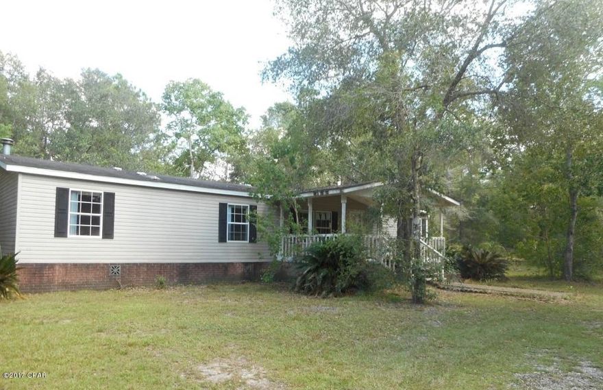 Great country property located on approximately 2 acres of land. Doublewide mobile home with 3BR/2B and open living atmosphere. Family room with fireplace. Split bedroom floorplan. Most of home has wood flooring. Master Bedroom with large walk in closet. Master Bath has garden tub and separate shower. Front porch with swing and large back deck. Attached covered carport with storage room. Workshop with attached carports located on the property. Being Sold ''AS IS''.