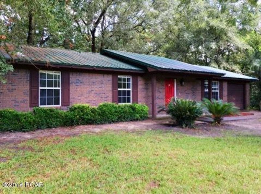 This is a solid brick home surrounded by a huge woodsy lot! Mature, beautiful shade trees, a fire pit, a cozy gazebo and a large workshop/storage shed are just a few reasons why this property is so inviting. Hook up your hammock and listen to the breeze rustling through the leaves or get out the grill and invite everyone over. The large open great room includes the living area, dining area and roomy kitchen with lots of cabinets and counter space and a breakfast bar. Built in shelves in the living area create architectural interest and storage. The master bedroom is spacious with bathroom en suite. The roof is metal and the lot is high and dry! The garage is currently sectioned off for an ATV or boat and a separate laundry room but can easily be opened back up for a full garage